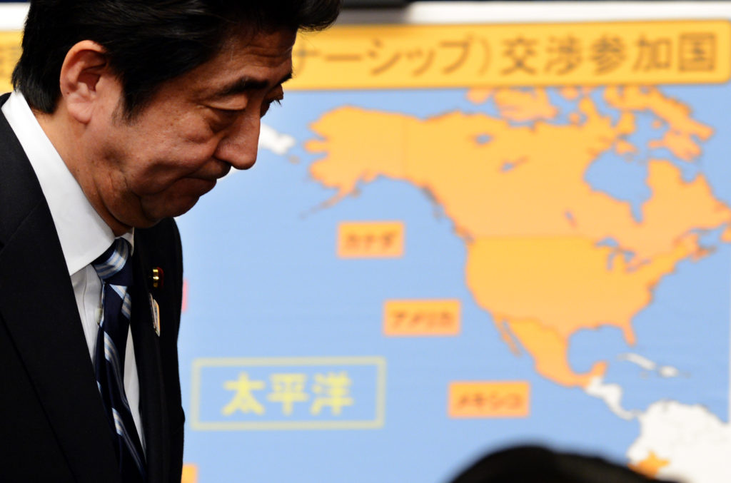 Shinzo Abe standing in front of a map of the United States.